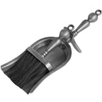 Hearth brush nested in a shallow silver-grey pan, showing dark bristles, baluster handles and circular hanging loops.