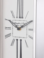 Close-up of the white dial showing black hands, minute markers and stretched Roman numerals beside the silver-tone rim.