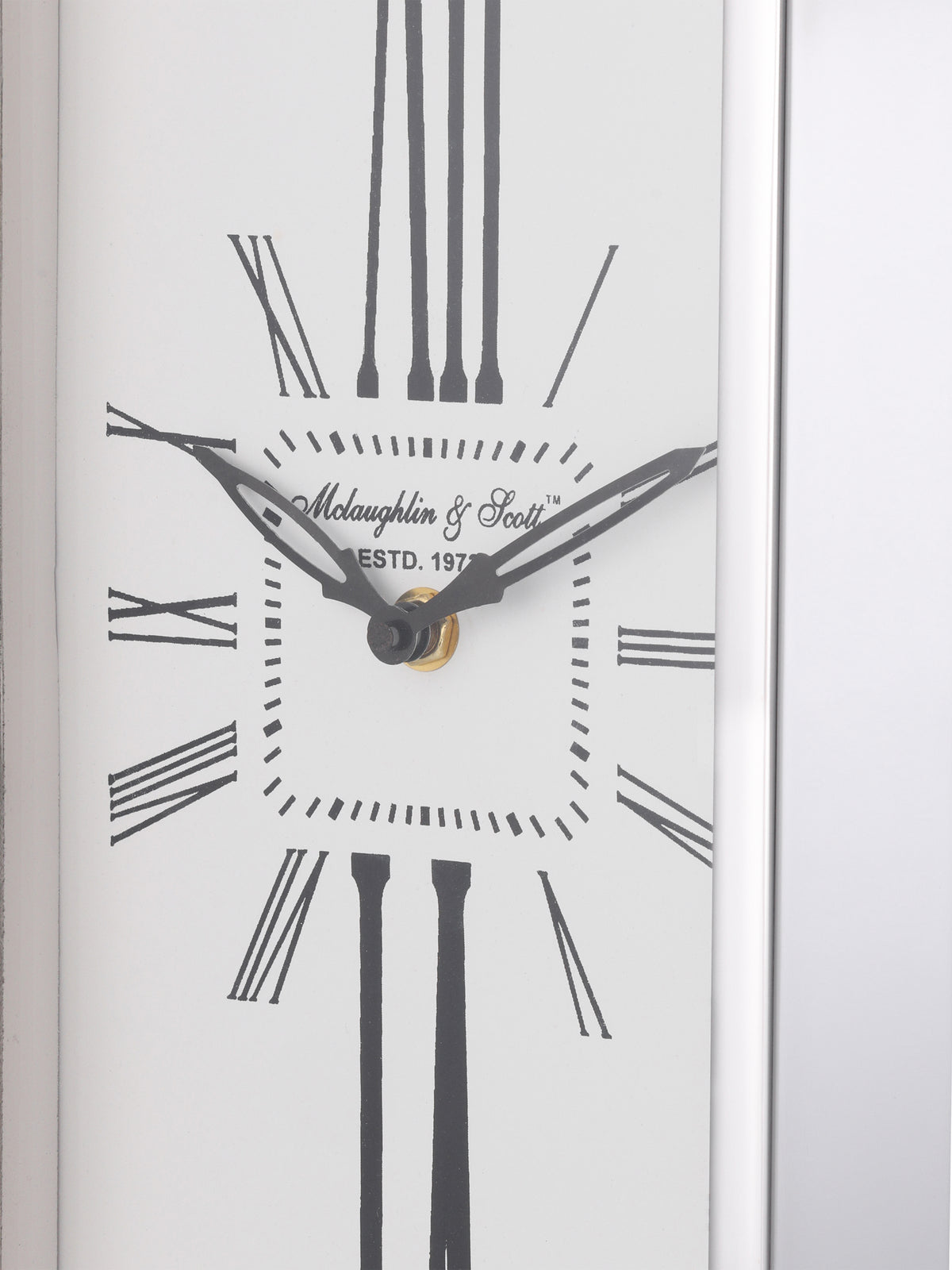 Close-up of the white dial showing black hands, minute markers and stretched Roman numerals beside the silver-tone rim.