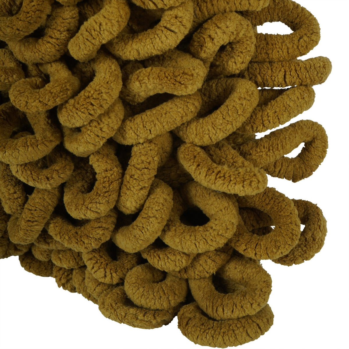 Close-up of the cushion corner with dense curled mustard loops extending beyond its edge.