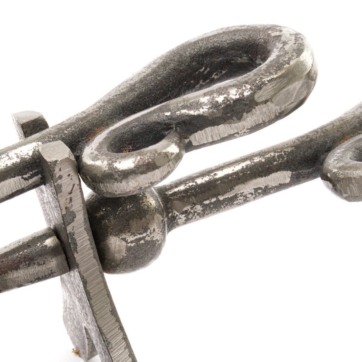 Close-up of the hearth tidy's crook-shaped looped ends and stems, showing the irregular mottled silver-grey finish.