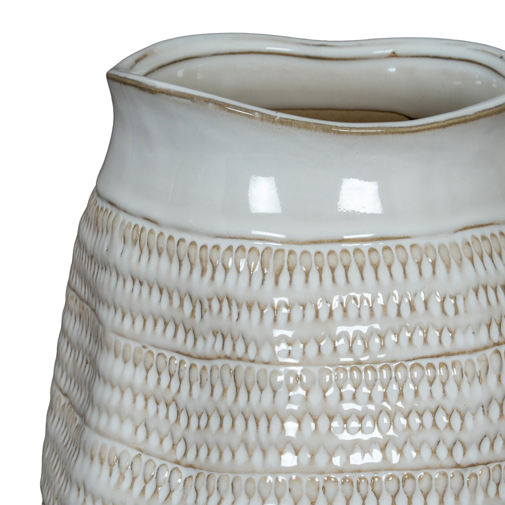 Detail of the vase's undulating rim above a smooth white band and repeated rows of recessed loop impressions.