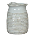 Full view of a glossy white vase with a wavy rim, pinched neck and rows of beige-accented loop impressions.
