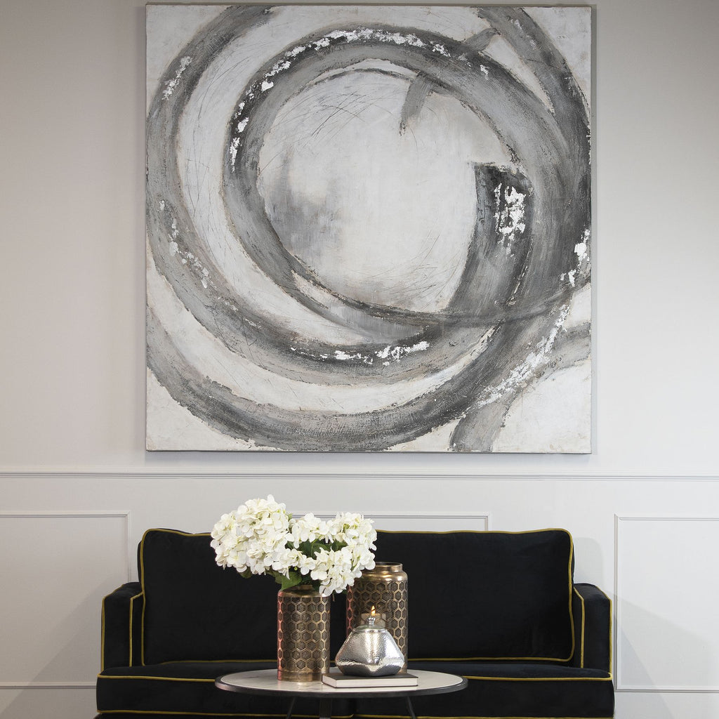 Looping Bands Wall Art displayed on a pale panelled wall above a black sofa, with white flowers and decorative vessels on a round table.