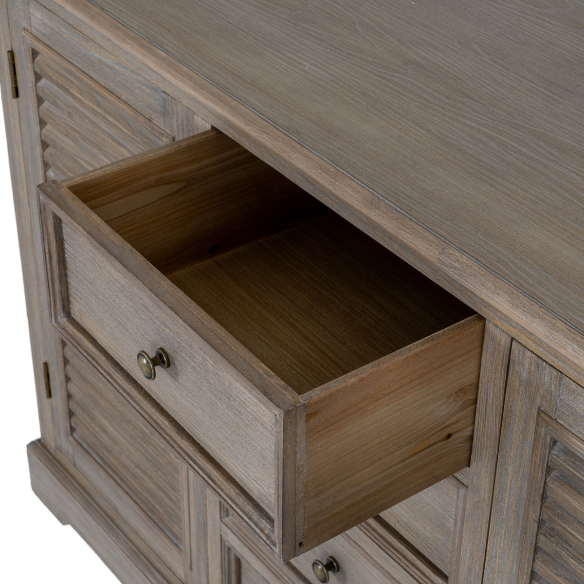Close view from above of an open central drawer, showing its empty interior beneath the grain-patterned top.