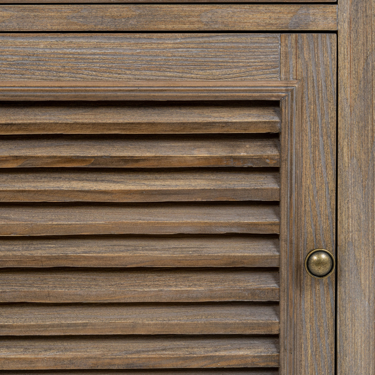 Close-up of the door's horizontal louvres, brown grain pattern, moulded frame and round metal-toned pull.