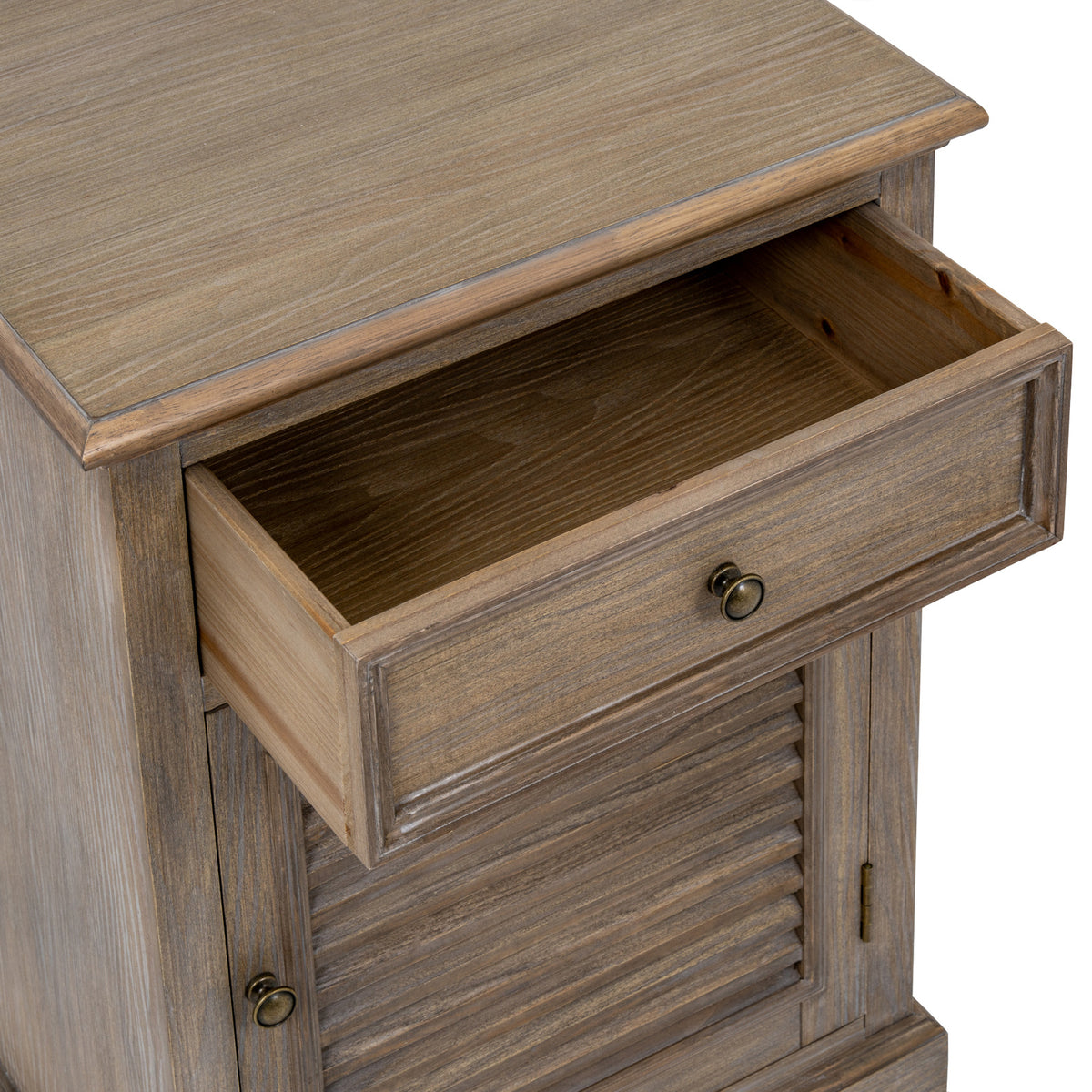 Angled close-up of the open upper drawer, showing its empty interior, framed front and round pull beneath the cabinet top.
