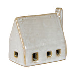 Angled view of the barn decoration showing openings on the long wall and left gable, with tan edging against its glossy off-white surface.