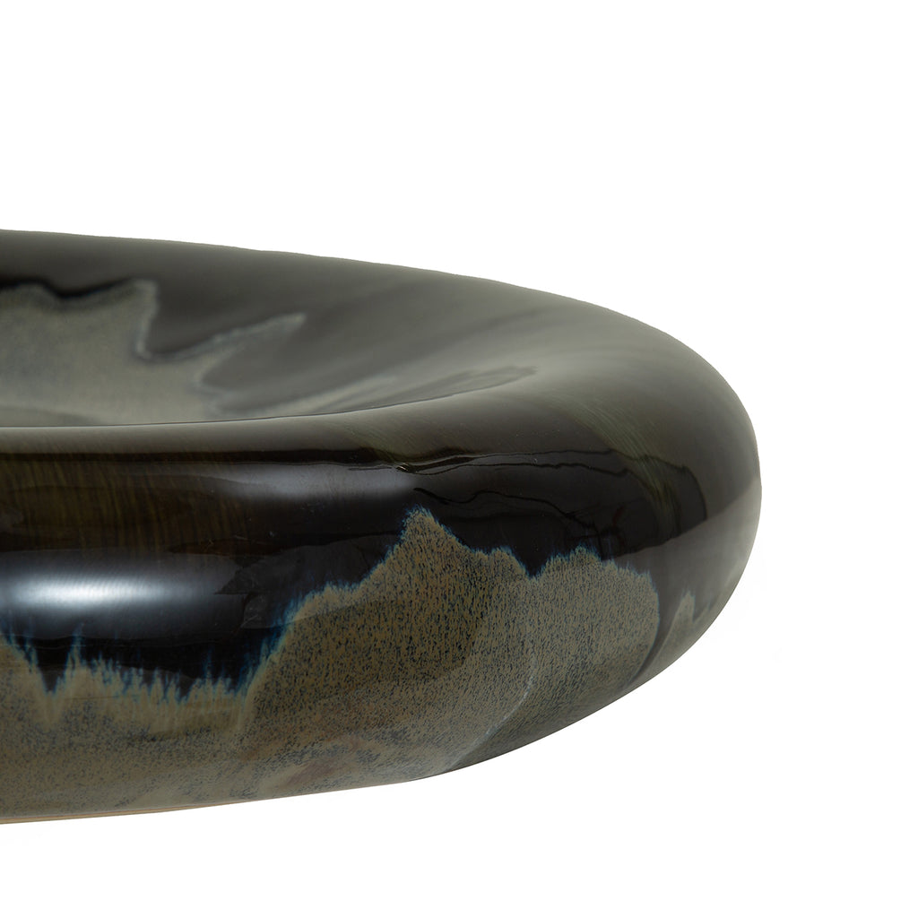 Close-up of the curved bowl rim showing glossy dark glaze meeting finely speckled grey with blue edges.