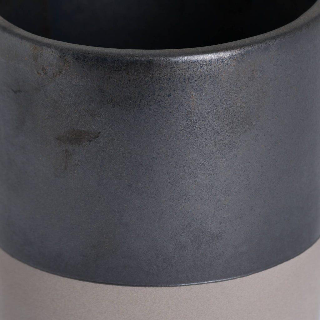 Close-up of the Lowband Planter showing its rounded rim, mottled metallic-grey surface and curved boundary above the pale lower band.