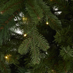 Close-up of fine green needles and flat-strip foliage, brown stem details and a green cable with several glowing warm-coloured bulbs.