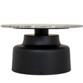 Front view of a round coffee table with a slim mottled top and a black pedestal that curves out to a broad base.