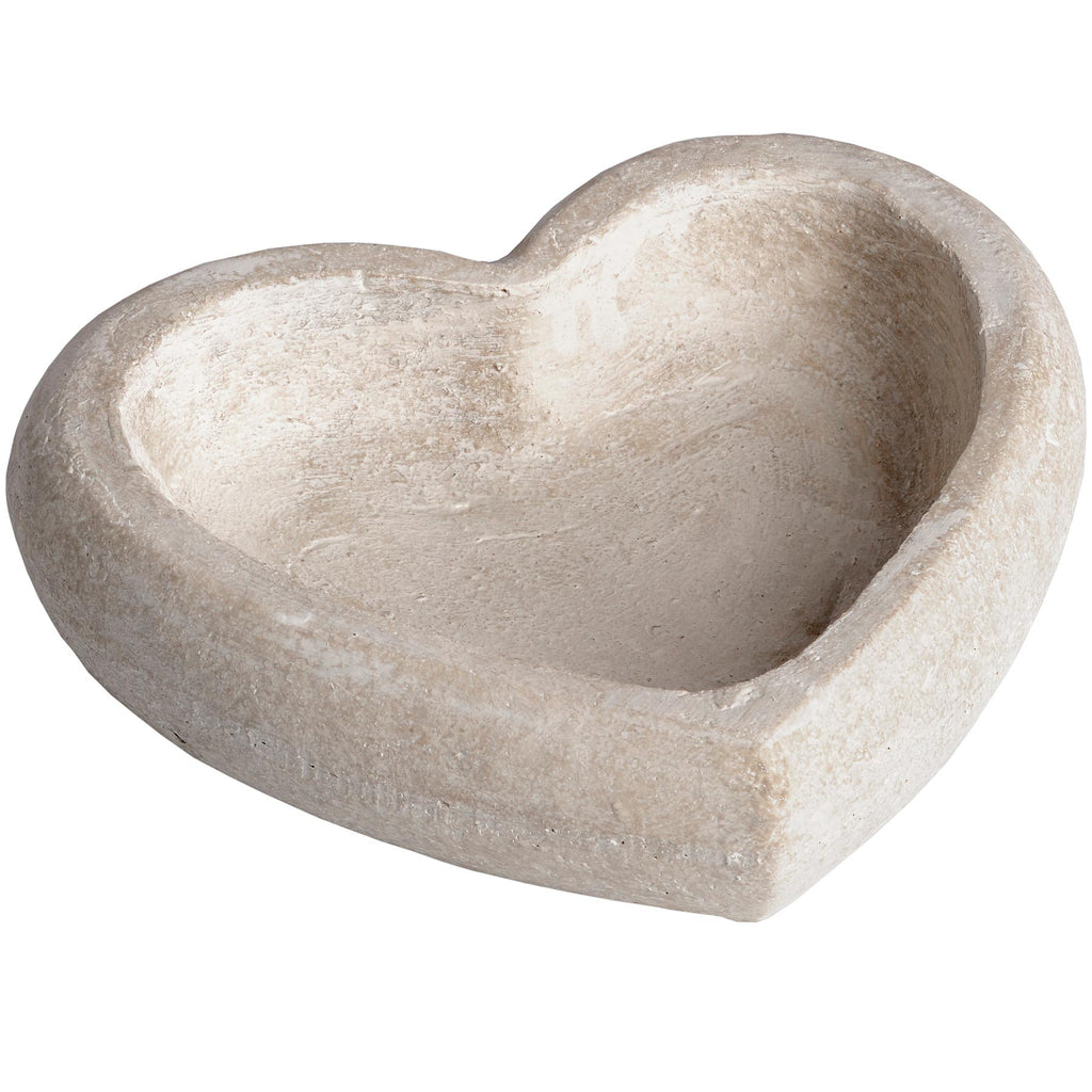 Cream-taupe heart-shaped decorative dish viewed at an angle, showing its thick rounded rim and recessed centre.