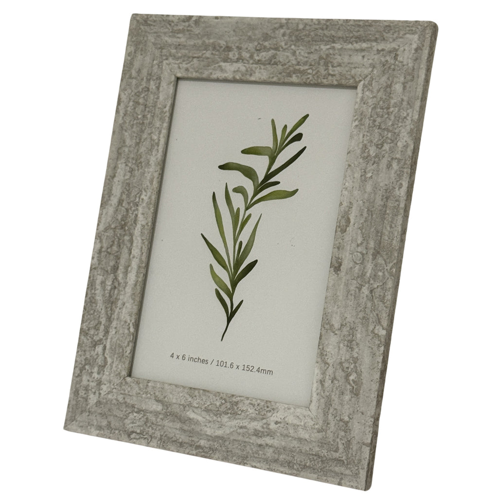 Angled front view of the marbled-looking photo frame, showing its inset ridge around a green botanical insert.