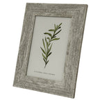 Angled front view of the marbled-looking photo frame, showing its inset ridge around a green botanical insert.