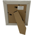 Rear view of the photo frame with its stand folded out, two hanging loops and a label warning against placement above or near a heat source.