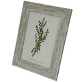 Angled front view of a pale grey-beige mottled photo frame with a broad ridged border surrounding a green botanical insert.