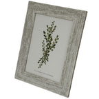 Angled front view of a pale grey-beige mottled photo frame with a broad ridged border surrounding a green botanical insert.
