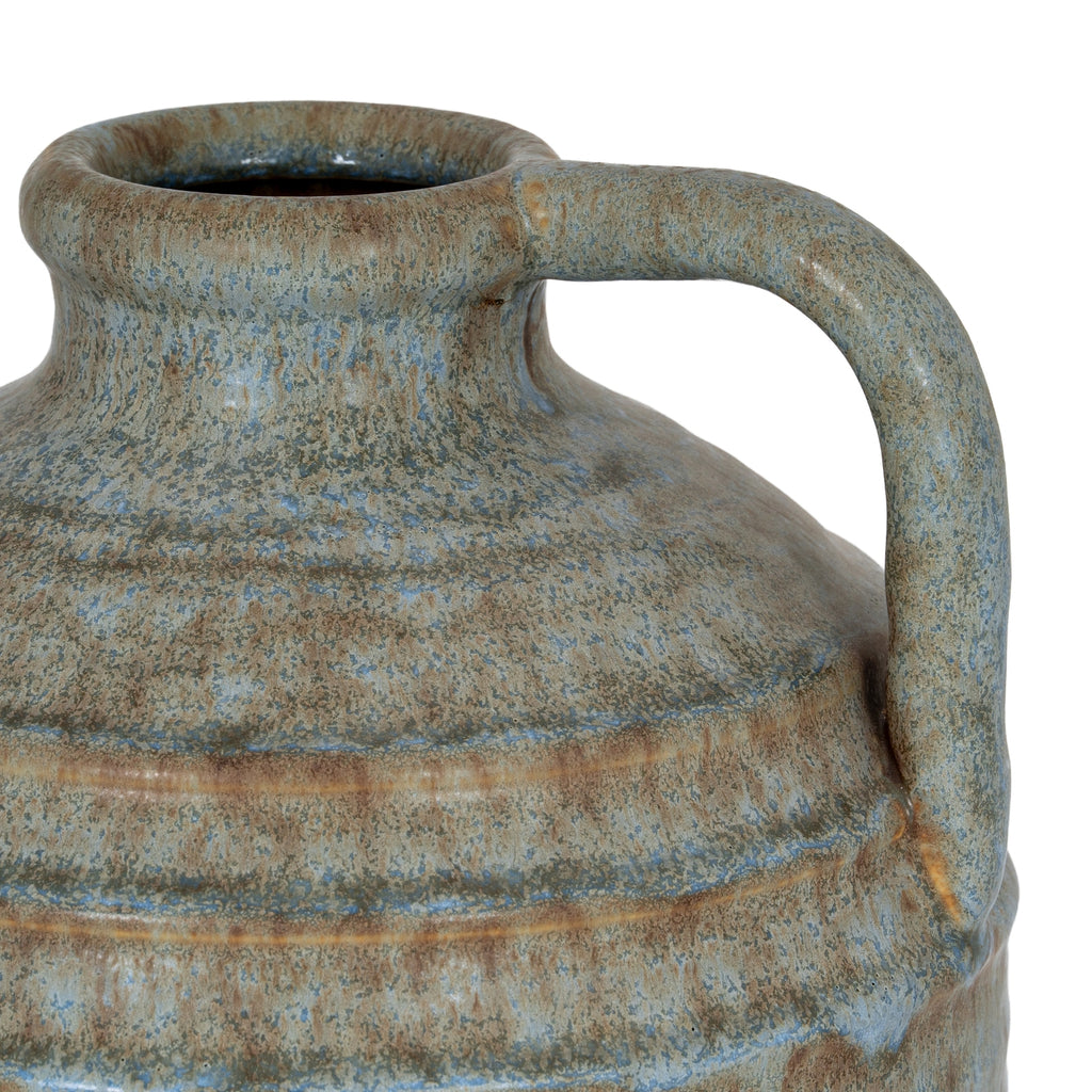 Close-up of the vase neck and high arching handle, with blue-grey and brown mottling across the raised shoulder bands.