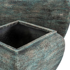 Close view of the smaller planter's raised square rim and dark interior, with green, teal and brown surface texture and the larger planter behind.