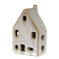 Tall off-white house decoration viewed from the front and right side, with a steep roof, chimney and open door and windows.