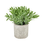 Artificial plant with dense elongated green leaves spreading above a cylindrical grey-beige stone-effect pot on a white background.