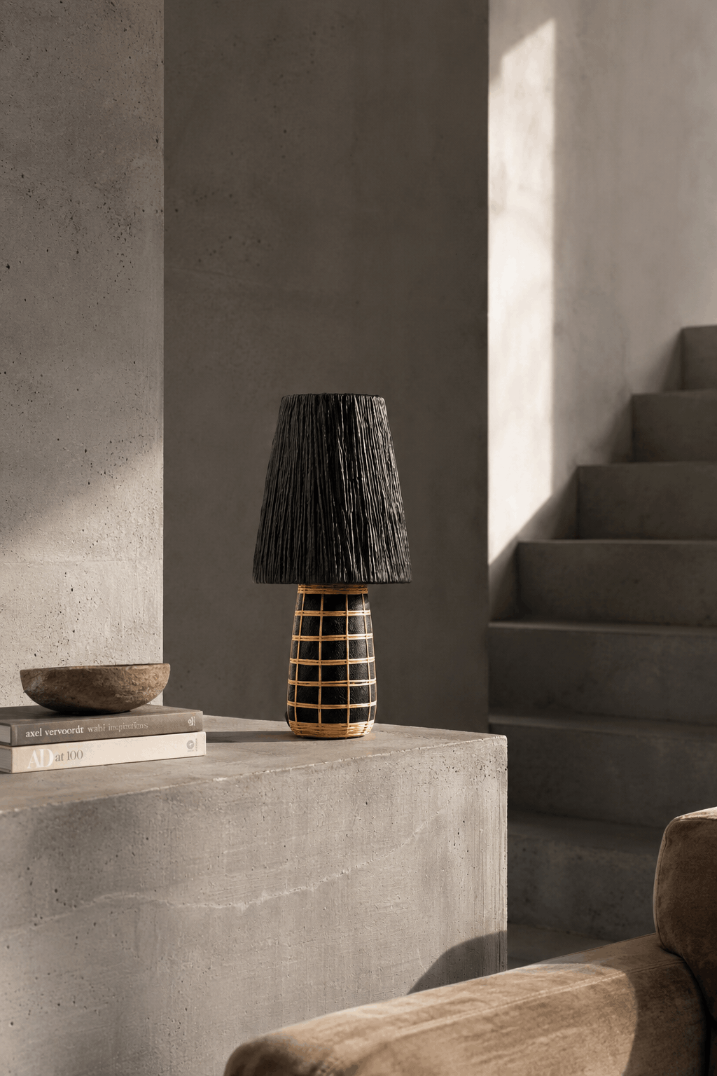 Naxos Terracotta & Grass Table Lamp – Black Natural – styled on a side table beside stairs