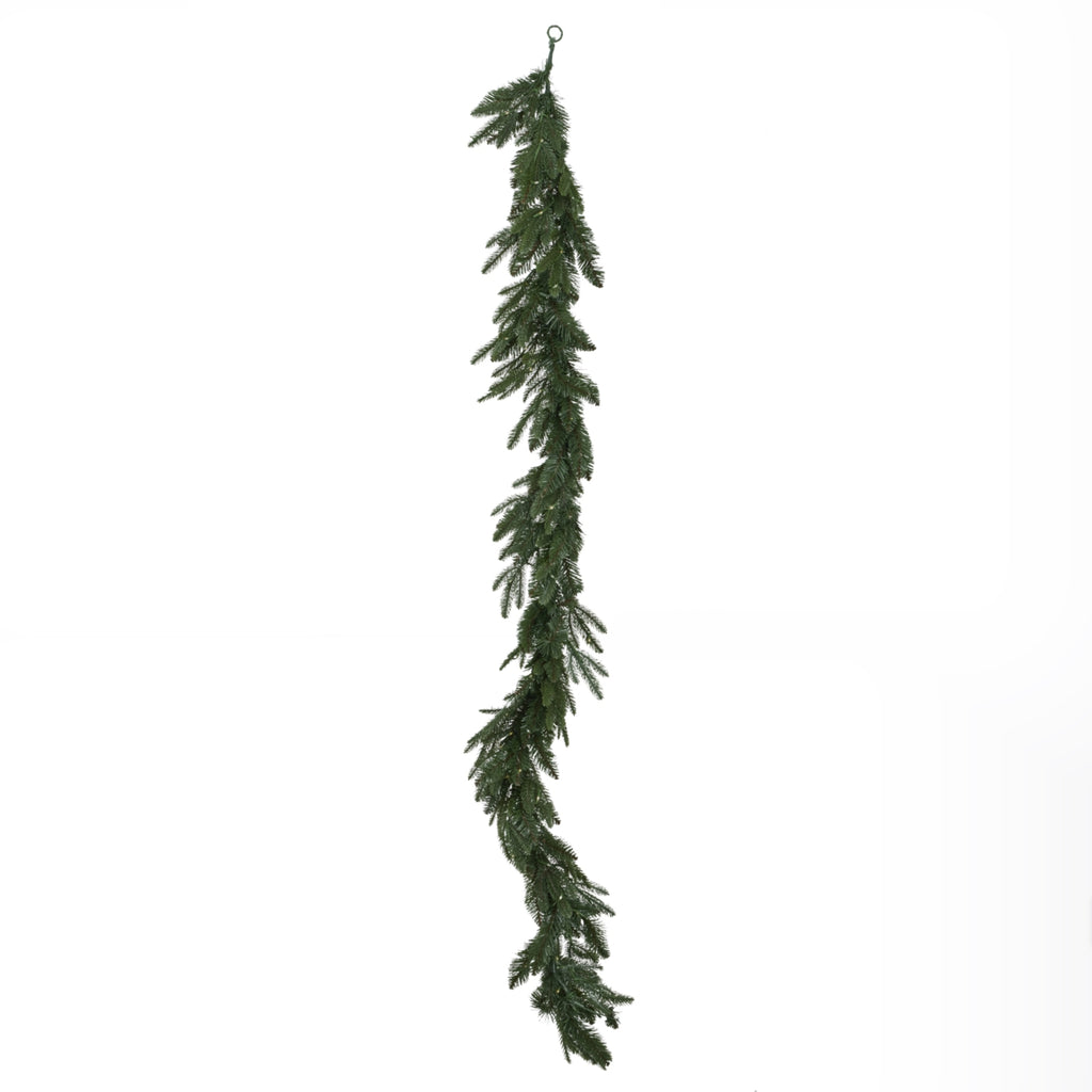 Green artificial garland hanging vertically against white, with a loop at the top and needle branches projecting along its length.