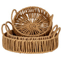 Three warm-brown round trays with the smallest tilted upright inside the others, revealing its open-weave base and raised loop handles.