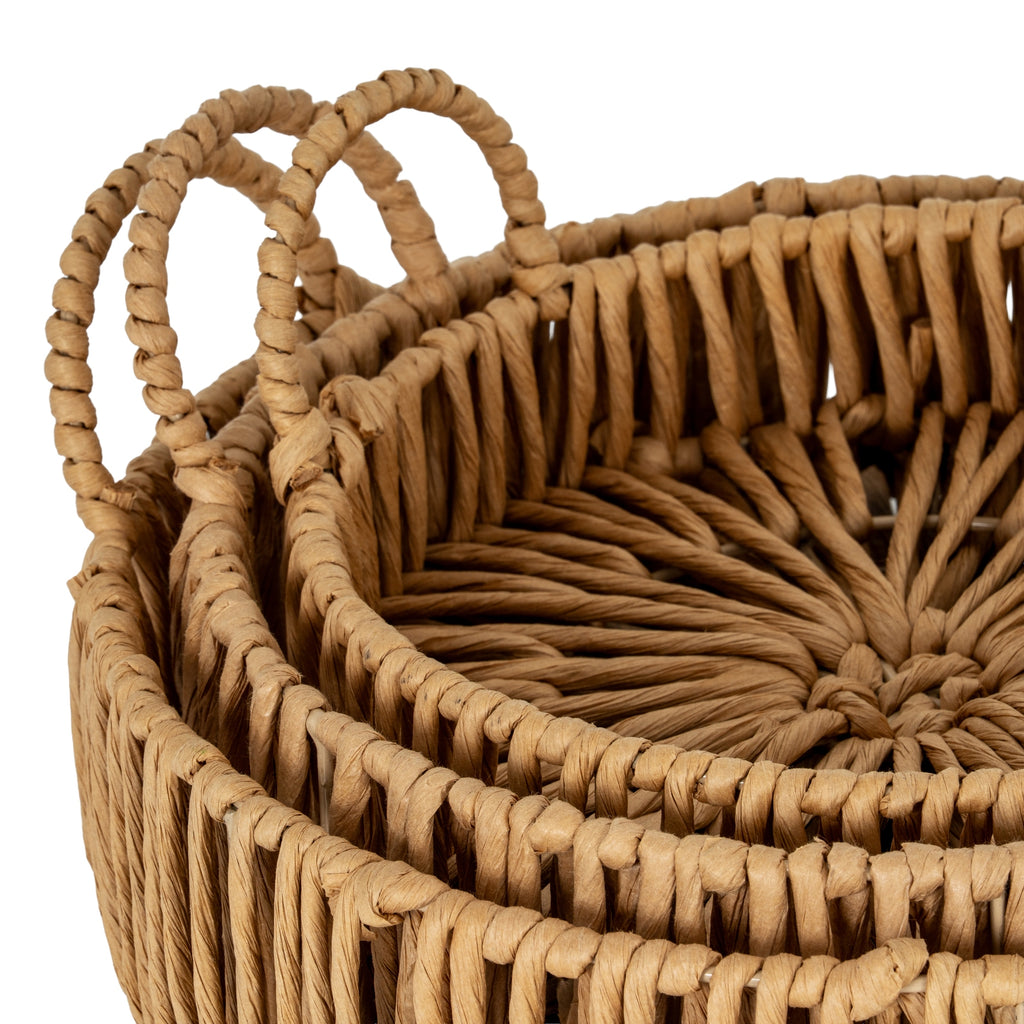 Close-up of the nested trays showing textured warm-brown loops around the rims, curved handles and the open pattern across the inner base.