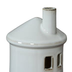 Close-up of the glossy white conical roof and cylindrical chimney, with brown edging at the chimney rim and square window openings below.