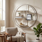 Circular wall shelf styled with books, a succulent, a framed botanical print and small ornaments beside a window and upholstered armchair.