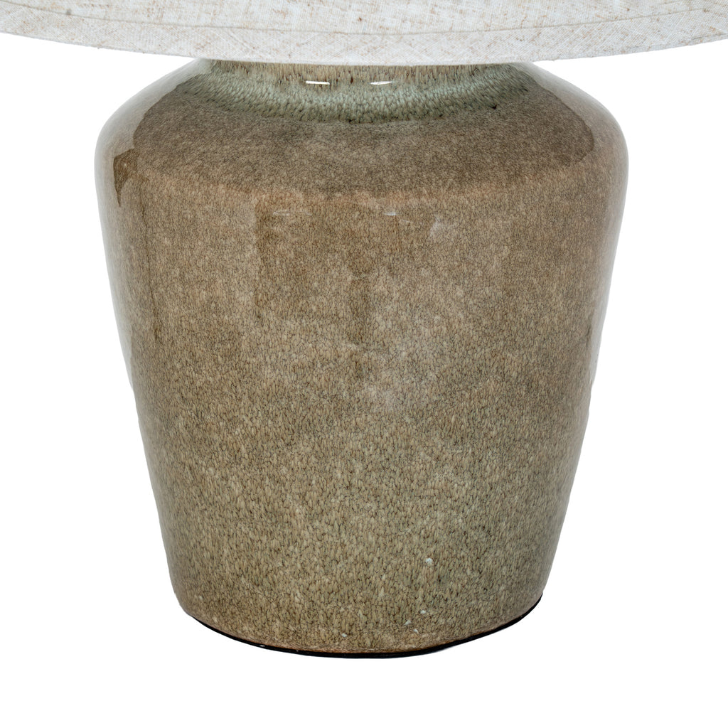 Close-up of the lamp's finely mottled olive and brown base, pale green-grey neck and cream shade edging.
