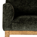 Close view of the chair arm, seat and inner back, showing the mottled olive upholstery above a grained brown rail.