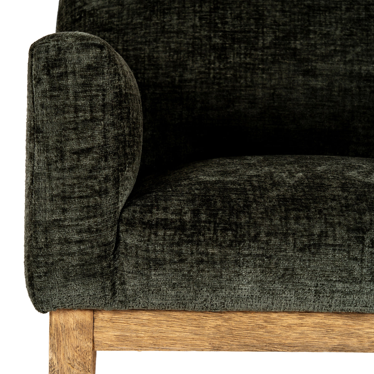 Close view of the chair arm, seat and inner back, showing the mottled olive upholstery above a grained brown rail.