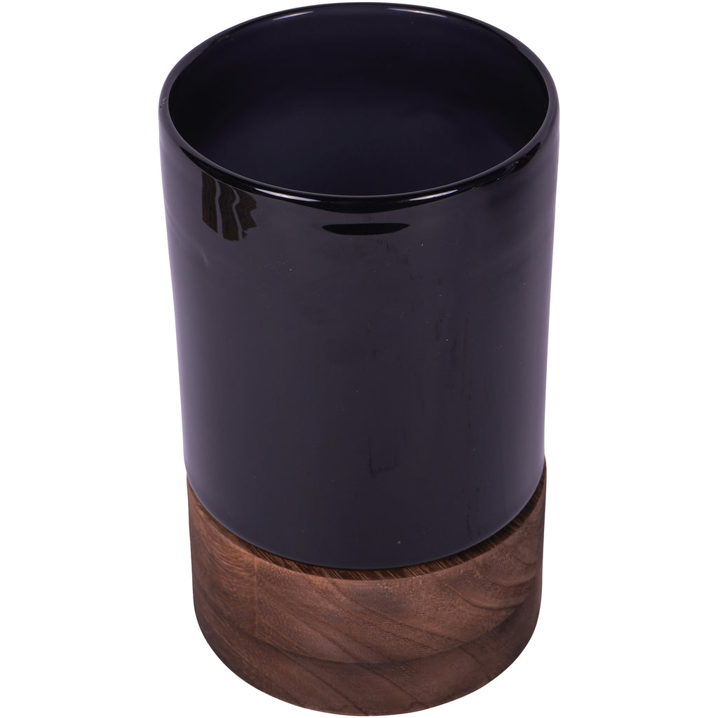 Elevated view of the black glass vessel showing its open top and round wooden base.