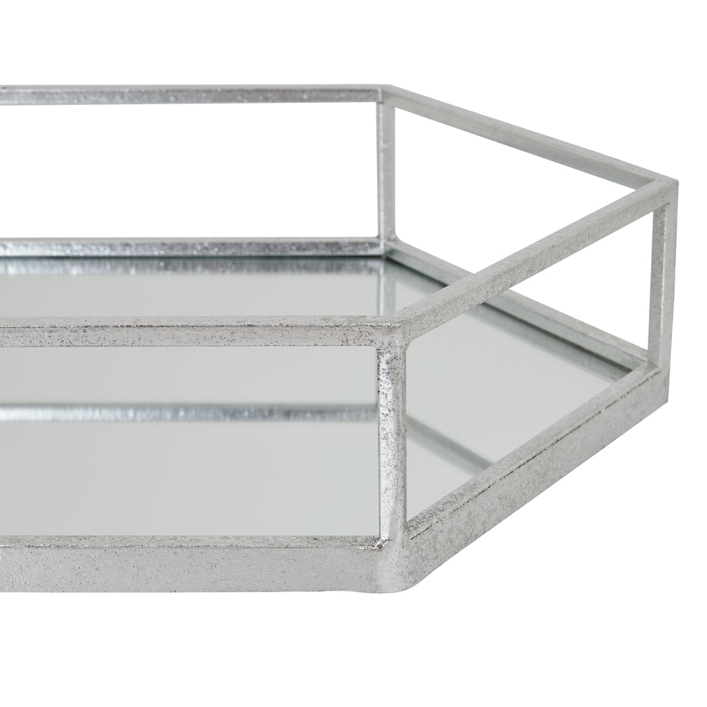 Close view of a tray corner where silver-toned rails meet above reflective side panels, with fine surface variation visible along the frame.