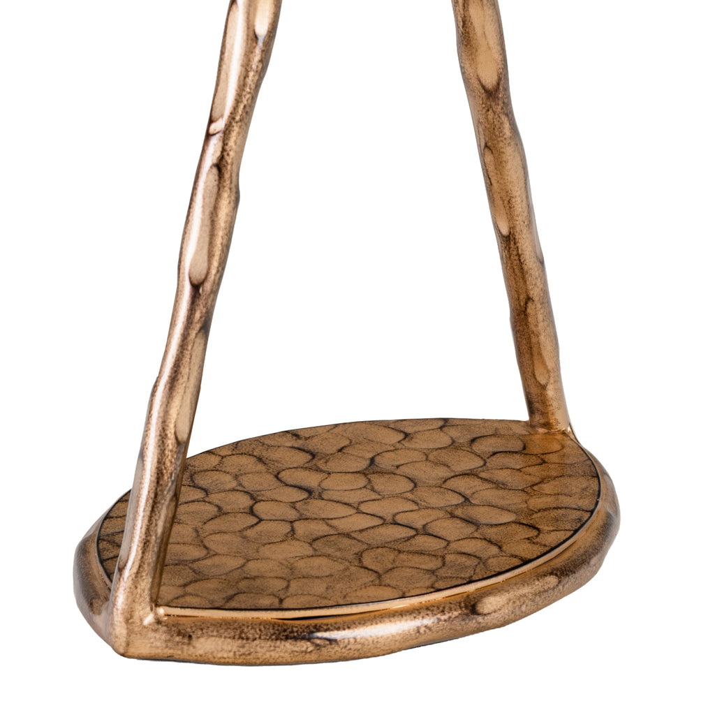 Close-up of the lamp's circular base, showing its dark curved pattern and textured gold frame.