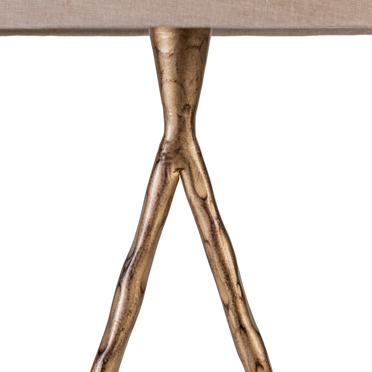 Detail of the hammered gold frame narrowing beneath the fabric shade before dividing into two sloping sides.