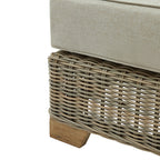 Detail of the footstool's open grey weave beneath the pale cushion, with a short wood-grain-effect foot visible below.