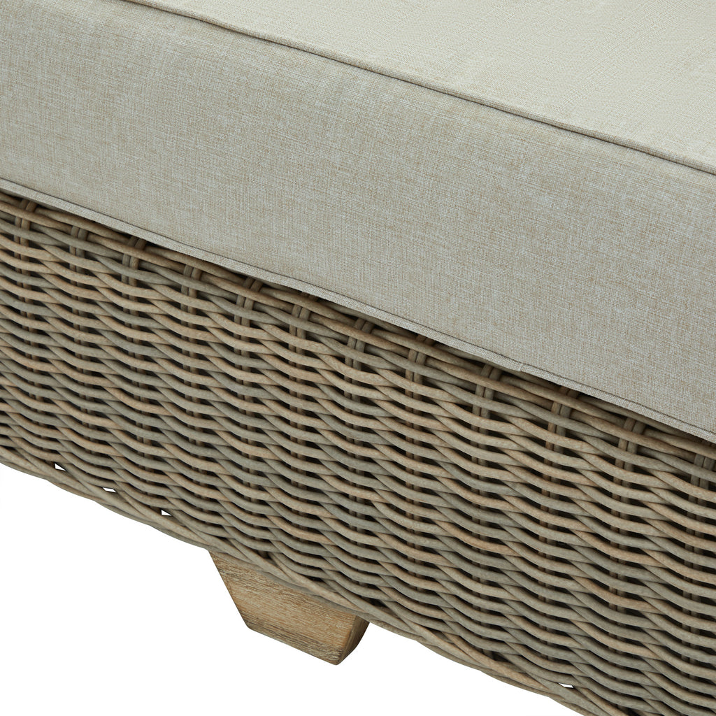 Detail of the pale seat cushion above the sofa's woven-looking front panel and a short foot with a light brown wood-grain appearance.