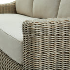 Close-up of the curved sofa arm with its grey weave pattern, with the pale seat and back cushions behind it.