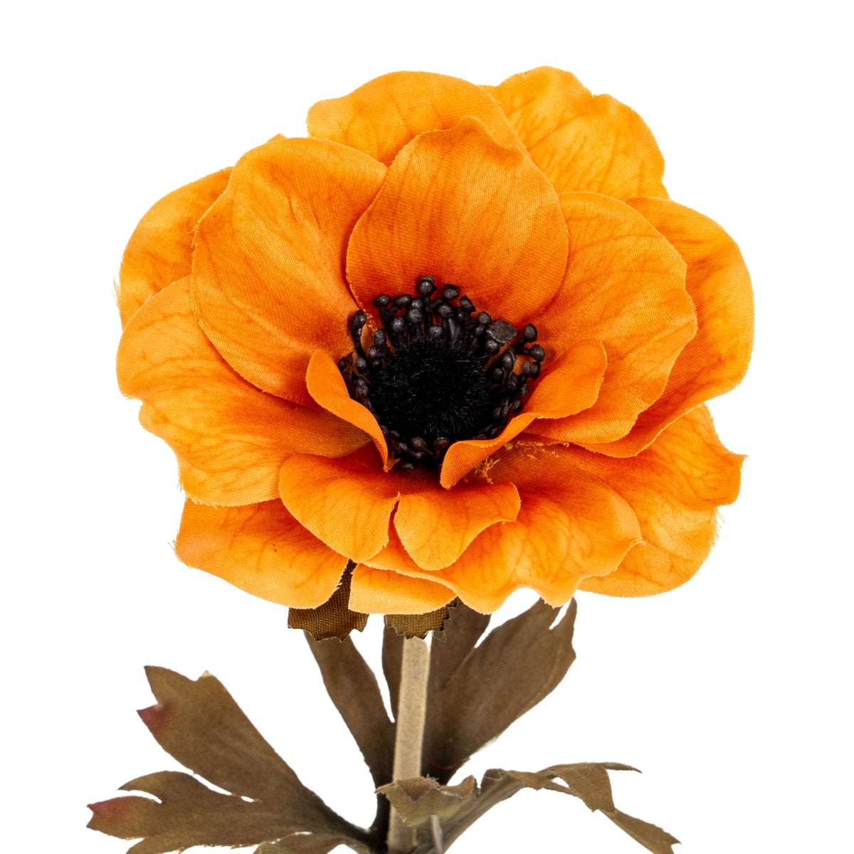Close-up of the orange artificial flower head, showing overlapping creased petals around a dark round centre, with part of the stem and leaves below.