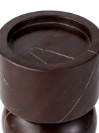 Close-up of the recessed top of the burgundy marble candle holder, with pale veins crossing the platform and rim.