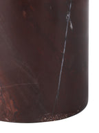 Close-up of the cylindrical marble base, showing chocolate and red tones, fine pale veins and its curved lower edge.