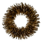 Full view of a circular decorative wreath with an open centre and overlapping brown, tan and olive feather-like forms on a white background.
