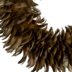 Close-up of the wreath's layered feather-like forms, showing fine edges, curved tips and grey-brown to warm-brown colour variation beside the open centre.