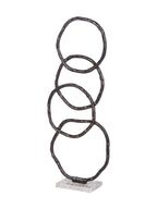 Angled view of the tall ring sculpture showing the overlapping curves and depth of its marble base.