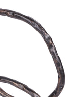 Close-up of an uneven ring edge with a dark textured finish and warm metallic highlights.