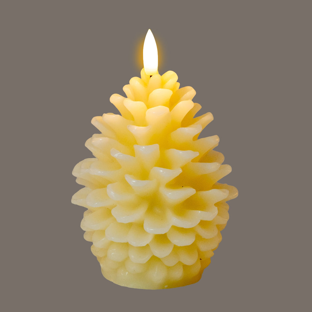 Cream pinecone LED candle pictured illuminated against a grey background, with yellow light visible between its layered scales.